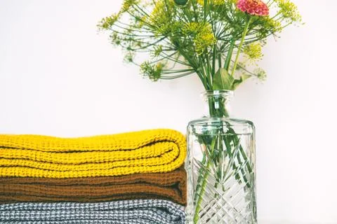 Stack of clean dry towels and vase with plants on table Stock Photos