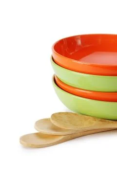 Stack of clean empty plates and wooden spoons  isolated on white background Stock Photos