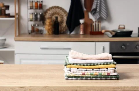 Stack of clean folded kitchen towels on wooden countertop in modern home kitc 스톡 사진