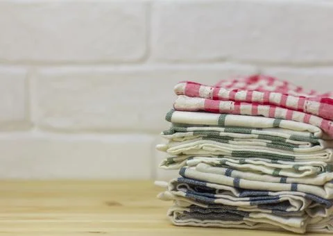 A stack of clean kitchen towels on the table. Stock Photos