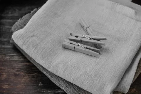 Stack of clean linen towels and clothespins on table Stock Photos
