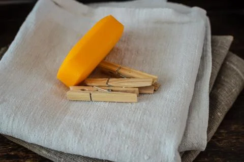 Stack of clean linen towels, clothespins and natural soap on table Stock Photos