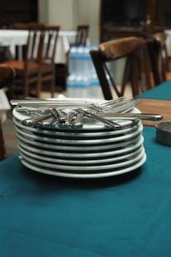 Stack of clean plates and silverware on a table Stock-Fotos