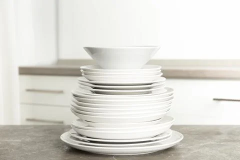 Stack of clean plates on marble table in kitchen 스톡 사진