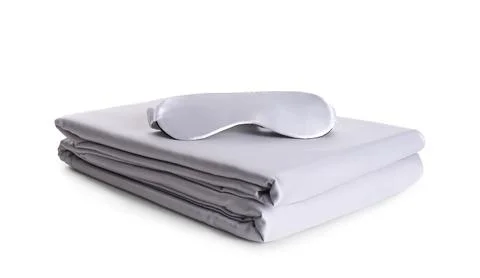 Stack of clean silky bed linen and sleeping mask isolated on white Stock Photos
