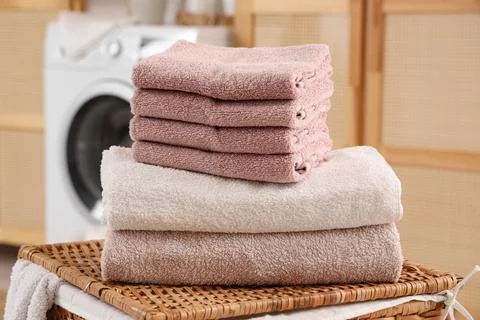Stack of clean soft towels on laundry basket in bathroom, closeup Stock Photos