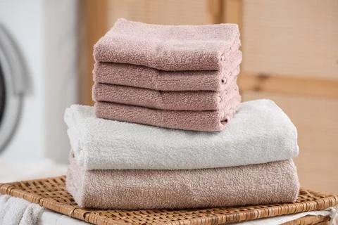 Stack of clean soft towels on laundry basket in bathroom, closeup Stock Photos