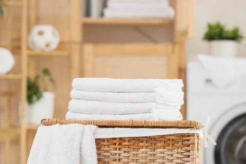 Stack of clean soft towels on laundry basket in bathroom, closeup Stock Photos