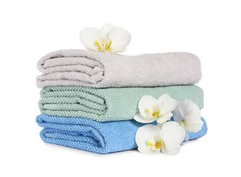 Stack of clean soft towels with orchids isolated on white Foto stock