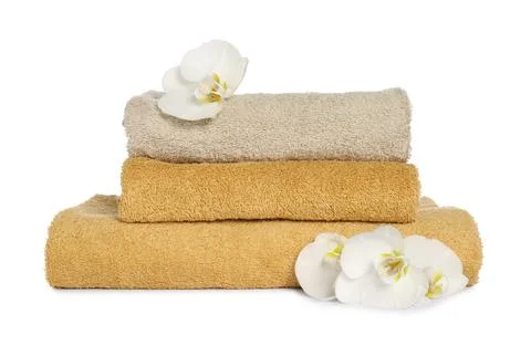 Stack of clean soft towels with orchids isolated on white Foto stock