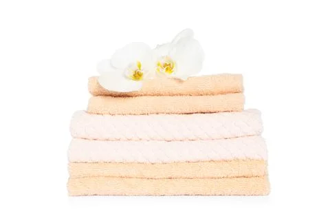Stack of clean soft towels with orchids isolated on white Stock Photos