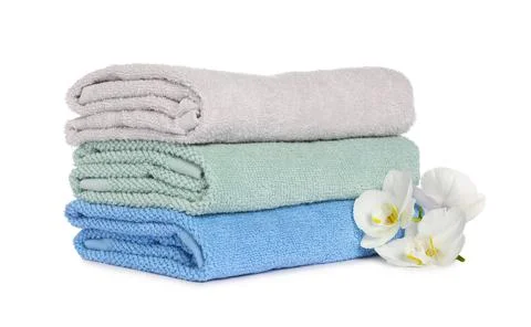 Stack of clean soft towels with orchids isolated on white Stock Photos