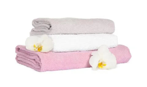 Stack of clean soft towels with orchids isolated on white 写真素材