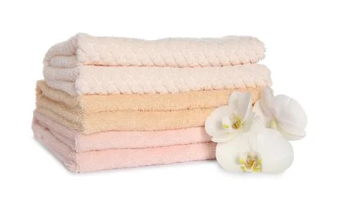 Stack of clean soft towels with orchids isolated on white Stock Photos