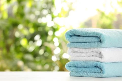 Stack of clean soft towels on table against blurred background. Space for tex Stockfoto's