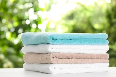 Stack of clean soft towels on table against blurred background 스톡 사진