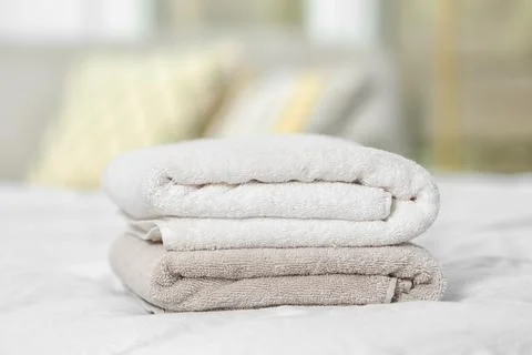 Stack of clean terry towels on bed, closeup 스톡 사진
