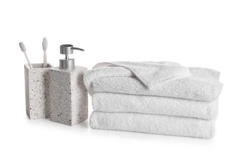 Stack of clean towels and bathing accessories isolated on white background Fotos de archivo