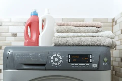 Stack of clean towels and bottles with household chemicals for washing on the Stock-Fotos