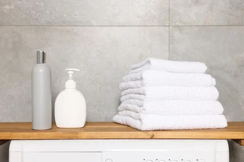 Stack of clean towels and cosmetic products in laundry room 库存照片