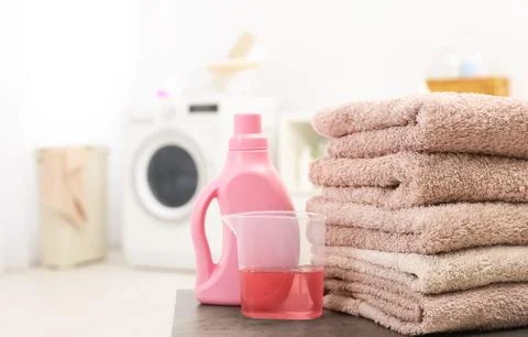 Stack of clean towels and liquid detergent on table in bathroom. Space for te Stockfoto's
