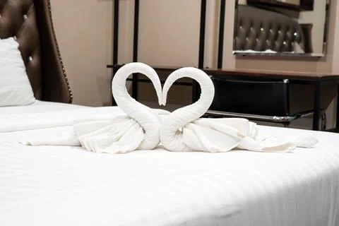 Stack of clean towels on bed in bedroom. Stock Photos