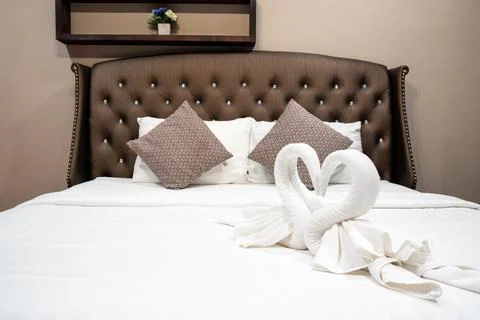 Stack of clean towels on bed in bedroom. Stock Photos