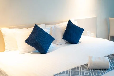 Stack of clean towels on bed in bedroom. Stock Photos