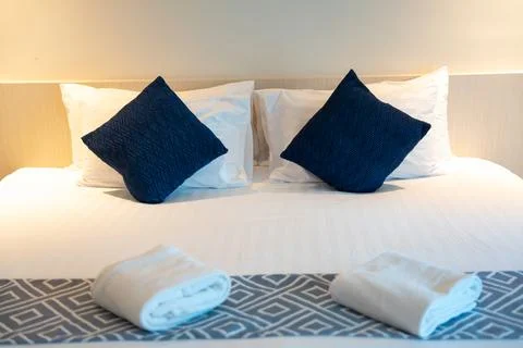 Stack of clean towels on bed in bedroom. Stockfoto's