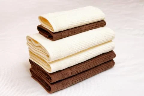 Stack of clean towels on bed Stock Photos