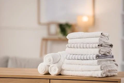 Stack of clean towels on commode in room Stock Photos
