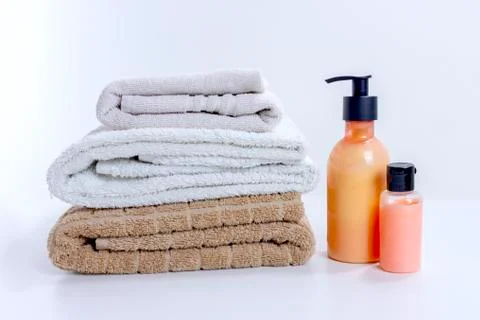 Stack of clean towels with cream and lotion for shower and bathroom treatment Stock Photos