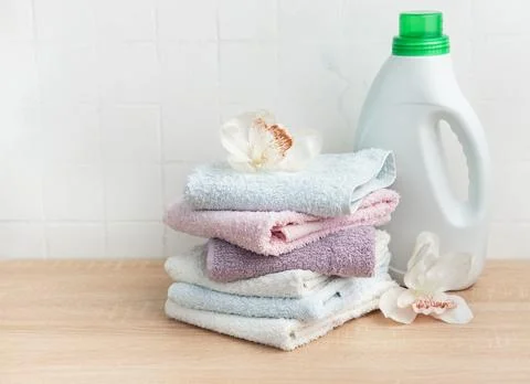 Stack of clean towels with laundry detergent bottle Stock Photos