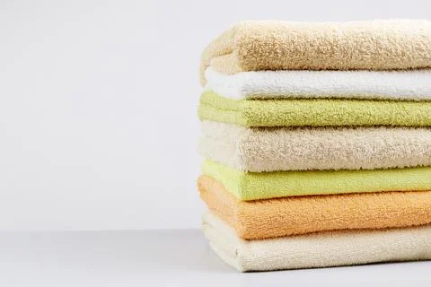 A stack of clean towels on a light gray background. Cotton towels on table Stock Photos