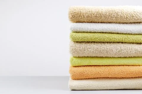 A stack of clean towels on a light gray background. Cotton towels on table Stock Photos