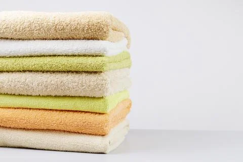 A stack of clean towels on a light gray background. Cotton towels on table Stock Photos