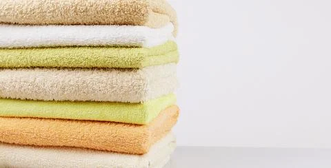 A stack of clean towels on a light gray background. Cotton towels on table Stock Photos