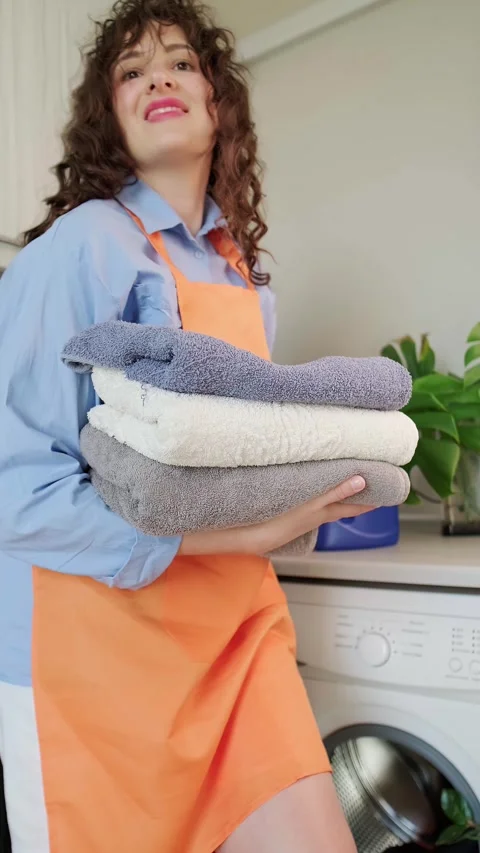 A stack of clean towels neatly folded. Home laundry with washing capsules - conv Stock Footage 295286128