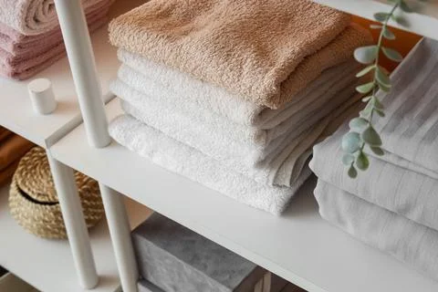 Stack of clean towels on shelf in room Stock Photos