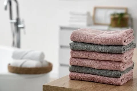 Stack of clean towels on table in bathroom Stock Photos