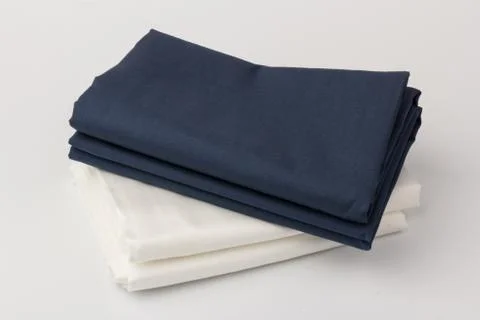 Stack of clean white and blue bed sheets on white  background, closeup. 스톡 사진