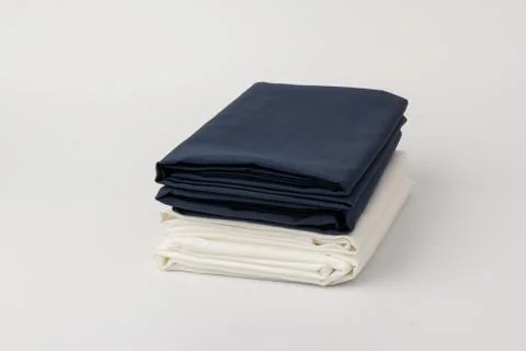 Stack of clean white and blue bed sheets on white  background, closeup. Stock Photos