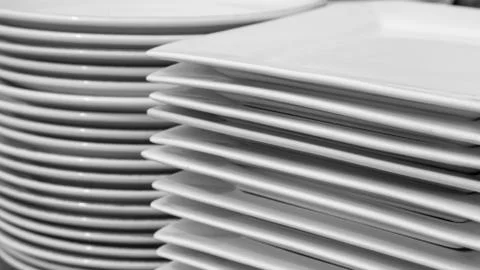 Stack of clean white round and square restaurant dishes Stock Photos