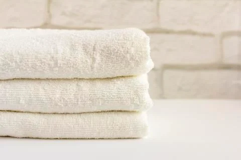 A stack of clean white Terry towels on a light background Stock Photos