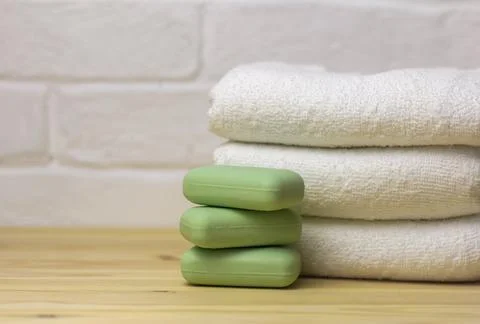 A stack of clean white towels and soap on the table. Foto stock
