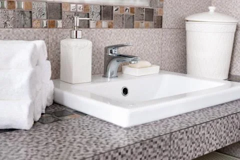 Stack of clean white towels on ceramic countertop in  bathroom Foto stock