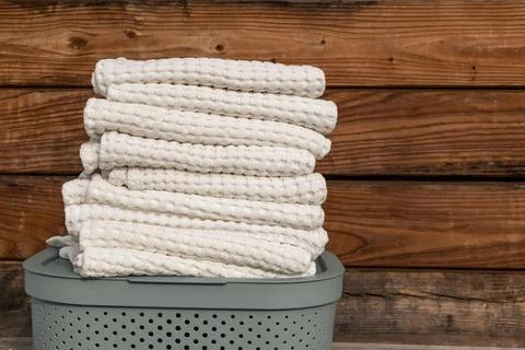Stack of clean white towels on a laundry basket. Stock Photos
