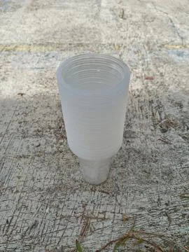 Stack of clear disposable plastic cups on concrete ground Stock Photos