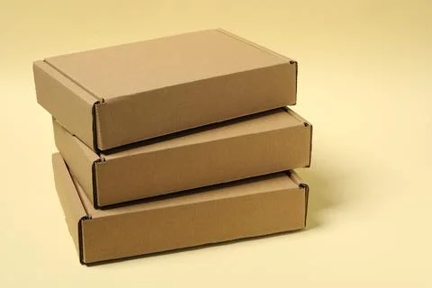 Stack of closed cardboard boxes on pale yellow background Foto stock