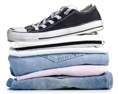 Stack of clothes and black sneakers Stock Photos